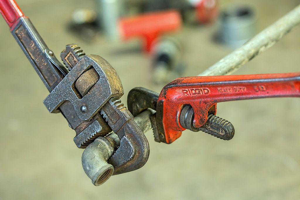Plumber's wrenches on a pipe fitting — plumbing businesses are one of Northline's specialties